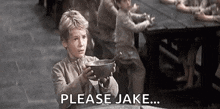 a young boy is holding a bowl of soup and saying `` please jake ... '' .