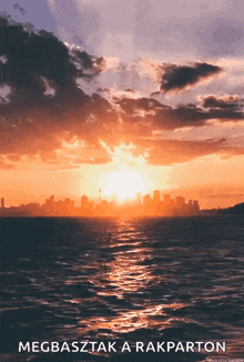 a sunset over the ocean with the words megbasztak a rakparton