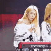 a girl singing into a nord stage 3 keyboard