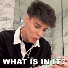a man in a black shirt is holding a bottle and says what is in it