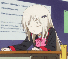 a girl sitting at a desk with her eyes closed and a bat on her ear