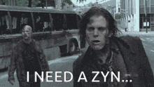 two zombies walking down a street with the words " i need a zyn "
