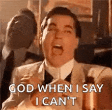 a man in a suit and tie is making a funny face and saying `` god when i say i cant '' .