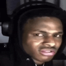 a young man wearing headphones is making a funny face .
