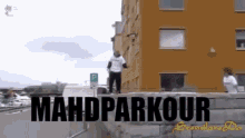 a man is doing a mahd parkour in front of a large building