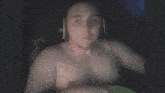 a shirtless man with headphones on looks surprised