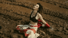 a woman is kneeling in the mud with a necklace that says ' i love you ' on it
