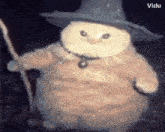 a cat is wearing a wizard hat and holding a staff .