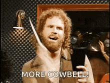 a man with a beard is talking on a cell phone and saying more cowbell .