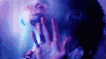 a close up of a person 's face with their hands on their mouth .