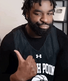 a man giving a thumbs up wearing a jersey that says h poin