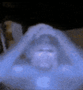 a blurry picture of a person 's face covered in a blue blanket .