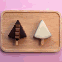two ice creams on a wooden tray one of which is shaped like a christmas tree