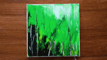 a painting on a wooden table with a green and black background