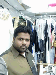 a man stands in front of a clothes rack