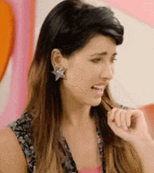 a close up of a woman wearing earrings with a star on them
