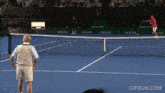 a man stands on a tennis court in front of a rolex sign