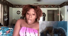 a woman in a pink top is sitting on a bed in a bedroom .