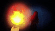 a hand is holding a torch in front of a woman