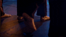 a person 's feet are barely visible on a dark floor