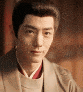 a close up of a young man 's face with a kimono on