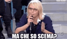 a woman wearing glasses is holding a microphone and says ma che so scemap