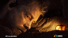 a man laying in the dirt with a nbc logo on the bottom