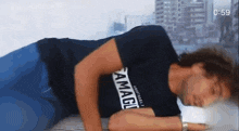 a man wearing a black shirt that says ' amager ' on it is laying down