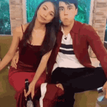a man and woman are sitting next to each other on a couch .