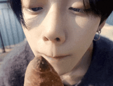 a close up of a person 's face eating a piece of bread