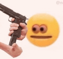 a person is holding a gun in front of a yellow smiley face on a white background .