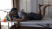 a man is laying on a table with a lchan watermark