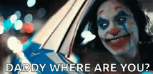 the joker is smiling and looking out of a car window .