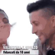 a man and a woman are kissing each other in a video .
