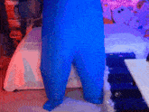 a person in a blue jumpsuit is standing in a bedroom