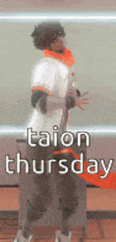 a man in a white shirt and orange scarf is standing in front of a sign that says taion thursday