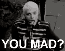 a black and white photo of a man with his tongue out and the words `` you mad ? '' .