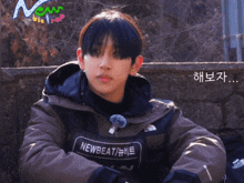 a young man wearing a jacket with the word newbeat on it
