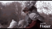a blurred image of a person surrounded by pigeons with the words made with flixier on the bottom