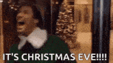 a man in a green sweater is laughing and saying `` it 's christmas eve '' .