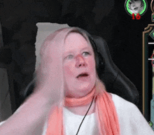 a woman wearing headphones and a scarf is playing a video game