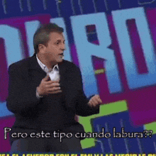 a man stands in front of a sign that says pero este tipo cuando labura