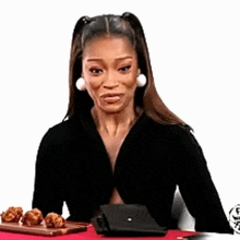 a woman is sitting at a table with a tray of food and her purse .