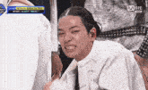 a man in a white suit and tie is making a face .