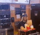 a woman is holding a tray of hamburgers and french fries in a mcdonald 's restaurant .