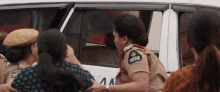 a woman in a police uniform holds a woman in a car