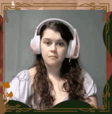 a woman wearing pink headphones looks at the camera