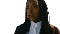 a woman with braids is wearing a white shirt and a brown sweater