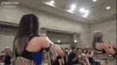 two women wrestling in front of a crowd with the word stardom on the bottom left