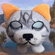 a stuffed animal with a cat 's face and blue eyes